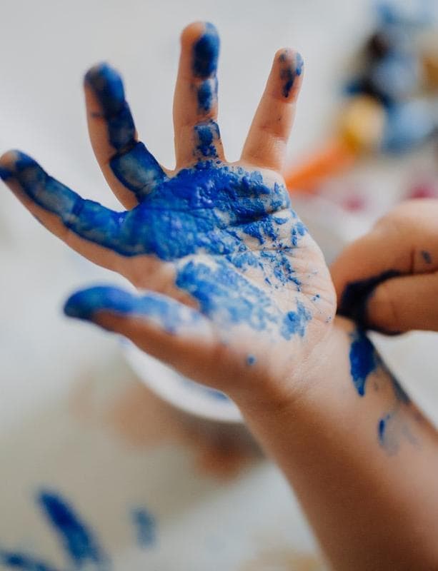 Close-up of a hand covered in blue paint