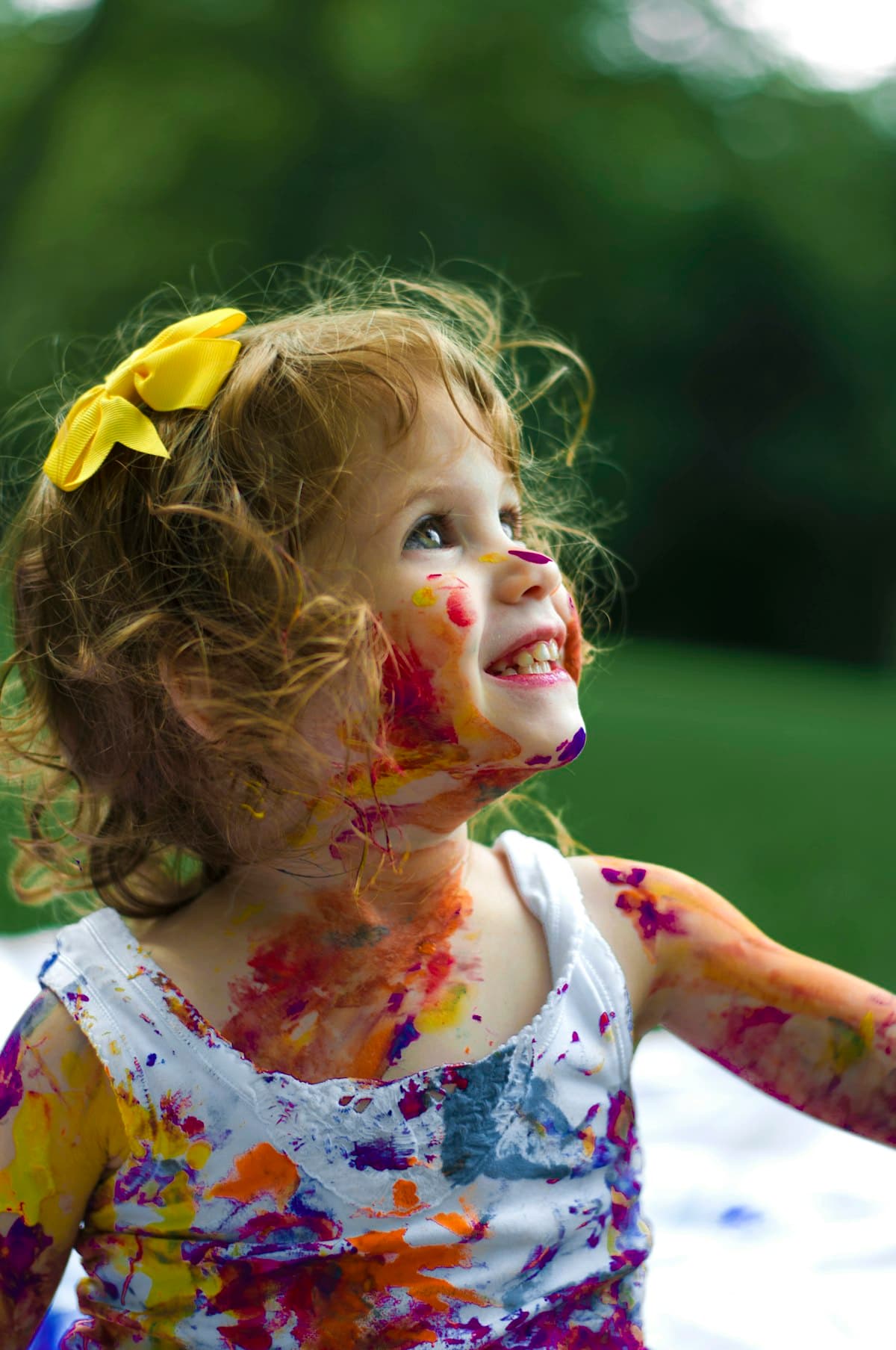 Smiling child covered in colorful paint